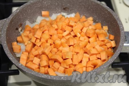К обжаренному луку выложить морковку, нарезанную на мелкие кубики, перемешать и обжаривать овощи минут 5, периодически перемешивая.