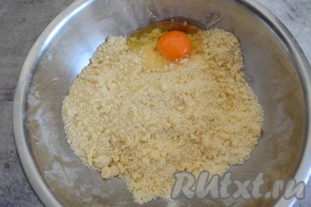 Перетереть руками масло с сухими ингредиентами до получения мелкой песочной крошки. Затем вбить сырое яйцо.