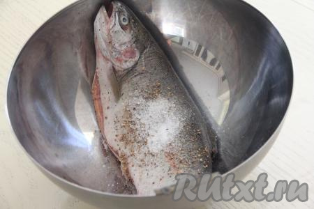 Выложить форель в миску, посолить хорошо рыбку и снаружи, и внутри. Также можно добавить ваши любимые специи для рыбы.