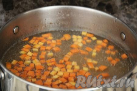В закипевший бульон выложить картошку и морковь, дать закипеть и варить на небольшом огне 15 минут.