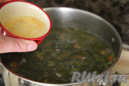 В небольшой ёмкости взбить яйцо вилкой до однородности. В закипевший суп тонкой струйкой, постоянно и интенсивно перемешивая, влить яичную смесь.