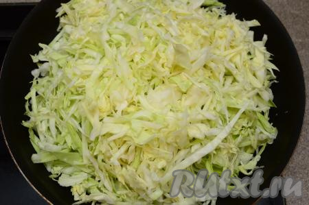 В сковороде разогреть растительное масло, выложить капусту. Начать капусту обжаривать на огне выше среднего, периодически аккуратно перемешивая.