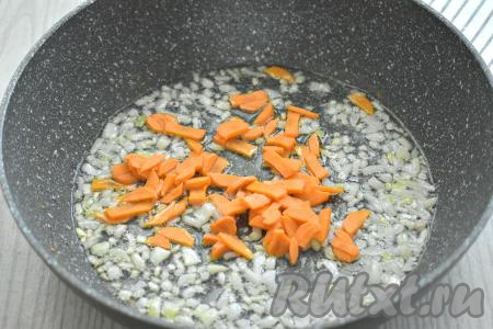 Морковь нарезаем на тонкие брусочки (или на полукружочки), добавляем к луку, сразу перемешиваем и обжариваем 4-5 минут, периодически помешивая.