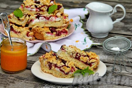 Нарезать аппетитный песочный пирог с сочной вишней и нежной меренгой на кусочки и, переложив на тарелку, подать к столу.