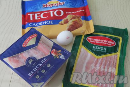 Подготовить продукты для приготовления сосисок в беконе в слоёном тесте. Покупное слоёное тесто можно взять как дрожжевое, так и бездрожжевое, разморозить его при комнатной температуре. Сосиски выбирайте качественные, от проверенного производителя.