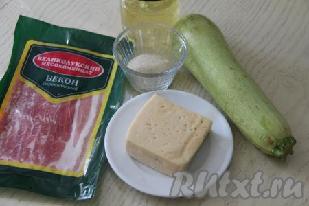 Подготовить продукты для приготовления рулетиков из кабачков с беконом и сыром в духовке. Для приготовления рулетиков нужно брать молодой кабачок с мелкими семечками. Если кожура у кабачка тонкая, её можно не срезать, достаточно будет обрезать у кабачка "кончики" с двух сторон. Вымыть кабачок.