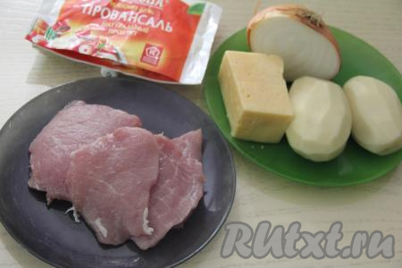 Подготовить продукты для приготовления мяса по-французски с картошкой на сковороде. Мякоть свинины вымыть, обсушить, нарезать на порционные кусочки, как для отбивных, толщиной примерно 1 сантиметр. Картошку, чеснок и лук почистить.