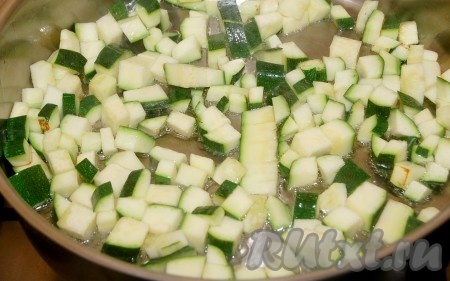 На сковородку налить растительное масло и выложить в него кубики кабачков. Обжаривать их 3 минуты.