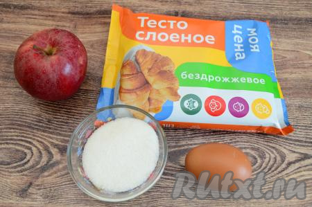 Подготовить продукты для приготовления булочек с яблоками из слоёного теста. Для приготовления этих булочек можно взять как бездрожжевое, так и дрожжевое слоёное тесто. Разморозить слоёное тесто при комнатной температуре. Для начинки можно взять 1 крупное яблоко или 2 небольших. Сладость яблок значения не имеет.