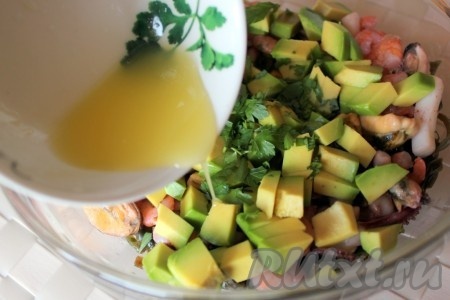 Авокадо очистить, порезать кубиками, добавить в салатник, посыпать рубленой свежей петрушкой, полить заправкой и перемешать.