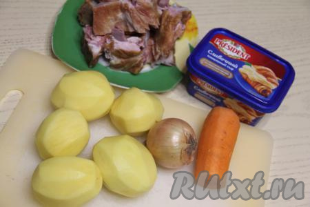 Подготовить продукты для приготовления сырного супа с копчёными рёбрышками. Копчёные свиные рёбрышки нарезать на части. Картошку, лук и морковь почистить.