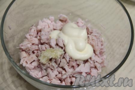 Копчёное куриное мясо нарезать на мелкие кубики, выложить в миску, добавить чеснок, пропущенный через пресс, и 2 столовых ложки майонеза.