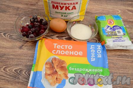 Подготовить продукты для приготовления слоек с ягодами и творогом. Слоёное тесто заранее разморозить. Я взяла для слоек бездрожжевое слоёное тесто, но подойдёт и дрожжевое. Ягоды можно взять как свежие, так и замороженные. Замороженные ягоды (я взяла замороженную чёрную смородину и вишню без косточек) можно не размораживать. Свежие ягоды нужно будет промыть, удалить косточки (если есть), затем немного обсушить, выложив на бумажное полотенце. Творог подойдёт любой жирности (у меня - жирностью 5%).