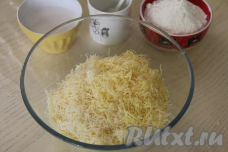 В миску с картошкой добавить сыр, натёртый на мелкой тёрке. 