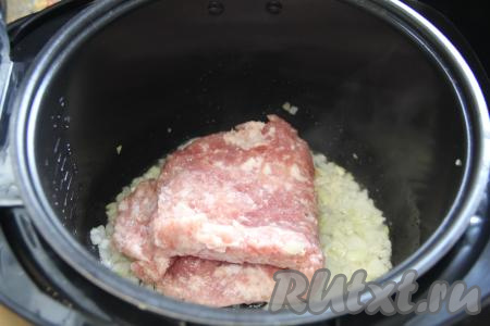 Пока варится картошка, можно заняться мясной начинкой для запеканки. Начинку для этой запеканки можно сделать из любого мяса (например, свинины, говядины, индейки, курицы или нескольких видов мяса). Для получения фарша нужно вымытое и обсушенное мясо попустить через мясорубку. Можно безусловно использовать и покупной фарш. Лук очистить. В чашу мультиварки влить растительное масло, установить на 20 минут режим "Жарка", выложить мелко нарезанный лук. Обжарить лук в течение 5 минут (до прозрачности), периодически перемешивая. Затем добавить мясной фарш (у меня - фарш из свинины).