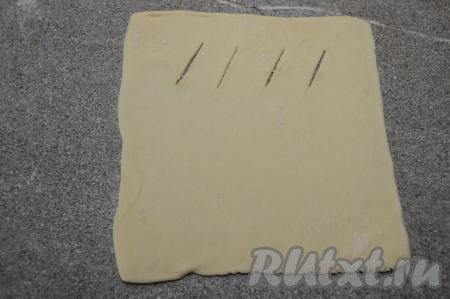 Ближе к одной из сторон квадрата, отступая от краёв теста 1-1,5 сантиметра, сделать 3-4 надреза острым ножом.