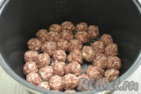 В съёмную чашу мультиварки вливаем растительное масло. Включаем мультиварку на режим «Жарка» на 12 минут. Когда прозвучит звуковой сигнал о том, что масло нагрелось, выкладываем в чашу сформированные фрикадельки в один слой. Обжариваем их до подрумянивания с двух сторон (в течение 5-6 минут с каждой стороны).