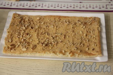 Орехи порубить ножом на небольшие кусочки. Присыпать крем орешками. 