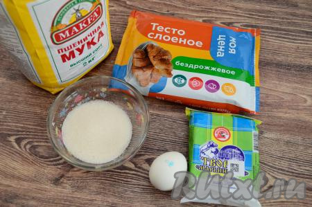 Подготовить продукты для приготовления рулета с творогом из слоёного теста. Заранее достать из морозилки слоёное тесто (можно использовать как бездрожжевое, так и дрожжевое слоёное тесто), оставить его размораживаться при комнатной температуре. Творог подойдёт любой жирности.