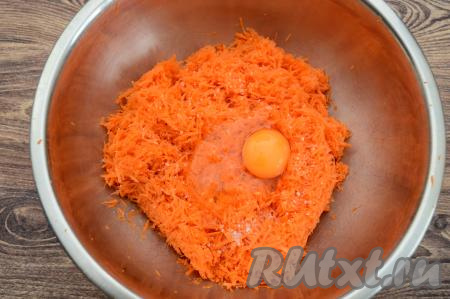 В миску с натёртой морковью добавить сырое яйцо и соль, тщательно перемешать.