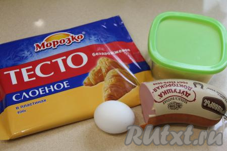 Подготовить продукты для приготовления булочек с колбасой и сыром из слоёного теста. Для формирования этих булочек подойдёт как слоёное бездрожжевое тесто (именно его я и использовала), так и дрожжевое слоёное тесто. Тесто достать из морозилки и разморозить при комнатной температуре (тесто должно стать достаточно мягким). Для этой выпечки лучше всего подойдёт варёная колбаса. Сыр можно взять как твёрдый, так и полутвёрдый. 