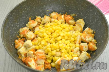 К курице, обжаренной с овощами, выкладываем консервированную кукурузу, перемешиваем, готовим 3 минуты, время от времени помешивая.