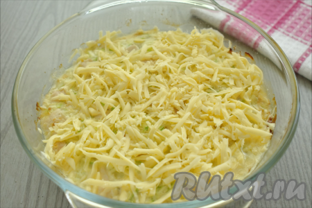 Затем достаём запеканку из кабачков с курицей из духовки, посыпаем её сыром, натёртым на крупной тёрке.