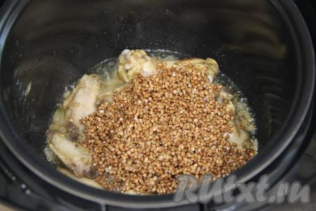К обжаренным частям курицы всыпать подготовленную гречку. 
