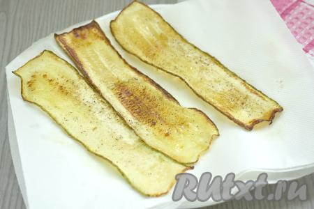 ​​​​​​​​Жареные полоски из кабачка выкладываем со сковороды на бумажные полотенца, чтобы удалить излишки масла. Постепенно жарим все полоски, даём им остыть.