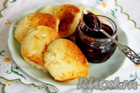 Пышные, вкусные, аппетитные сырники, приготовленные из творога и манки, переложить из чаши аэрогриля на тарелку и подать к столу с вареньем, сметаной или любимым сладким соусом.