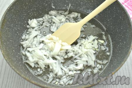 Пока варятся макароны, разогреваем на сковороде растительное масло, выкладываем в него мелко нарезанную очищенную луковицу, обжариваем на среднем огне минуты 3-4 (до прозрачности лука), периодически перемешивая. 