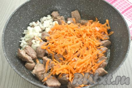 К обжаренному мясу индейки выкладываем мелко нарезанный лук и натёртую на крупной тёрке морковку, перемешиваем. Готовим на среднем огне минут 5-6, время от времени перемешиваем.