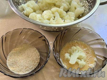 Отваренную капусту откинуть сразу на дуршлаг, чтобы она не переварилась, лишней воде дать стечь. Дать капусте немного остыть.  В одну миску взбить сырое яйцо, слегка посолить, взболтать вилкой до однородности. В другую миску всыпать панировочные сухари. Каждое соцветие капусты окунуть сначала в яйцо, покрывая всё соцветие.