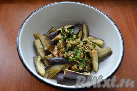 Если кусочки баклажанов слишком крупные - разрежьте их ещё на несколько частей. Баклажаны выложить в миску, добавить заправку.