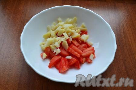 Помидоры нарезать кусочками, добавить нарезанный кубиками очищенный картофель.