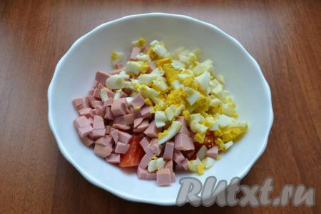 Яйца очистить и нарезать кубиками. В салат из картофеля и помидоров добавить нарезанные яйца и нарезанную кубиками колбасу.