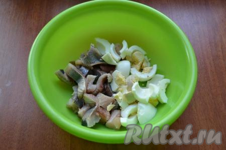 Филе сельди нарезать кусочками, добавить нарезанные вареные яйца.