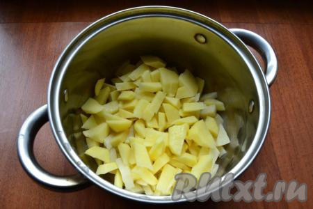 Картошку, лук и морковь очистить. В кастрюлю нарезать небольшими кусочками картофель, затем влить 2 литра воды, поставить на огонь, довести до кипения, снять пену, огонь уменьшить и варить картошку 20 минут.