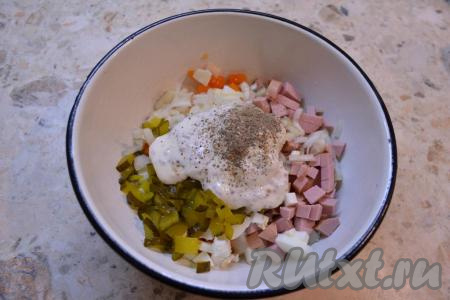 В салат с колбасой, картошкой, морковью и яйцами добавить нарезанный маленькими кубиками маринованный огурец. Маринованный лук отжать и также отправить в салат вместе со сметанно-горчичной заправкой. Салат посолить и хорошо поперчить.