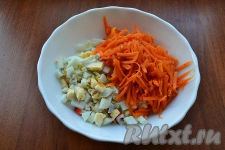 Добавить корейскую морковь, немного измельченную ножом, а также нарезанные вареные яйца.