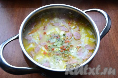 Всыпать соль, специи по вкусу, варить сырный суп с сосисками далее до тех пор, помешивая, пока не расплавится весь плавленный сыр.