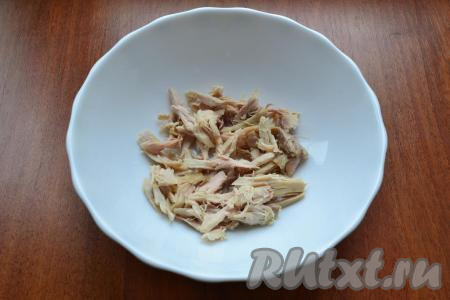 Вареное куриное мясо нарезать или разобрать на волокна.