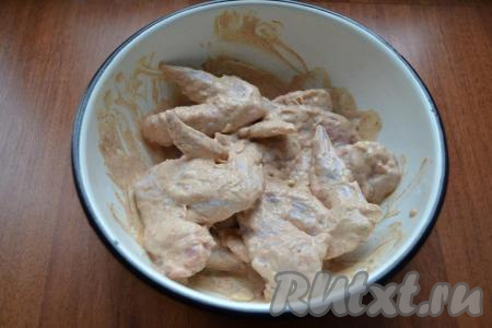 Перемешать куриные крылья с горчичным соусом и оставить в прохладном месте на пару часов для маринования.