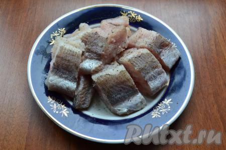 Нарезать рыбу кусочками шириной около 2 см, посолить их и поперчить.