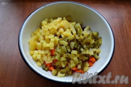К свекле и моркови добавить очищенный и нарезанный кубиками картофель, нарезанные такими же кубиками маринованные огурцы.