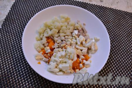 К нарезанным моркови и курице добавить нарезанные кубиками картофель и яйца.