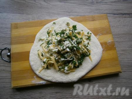 Раскатать каждый шарик из теста в небольшую лепешку, в центр которой выложить часть начинки из сыра и зелени.
