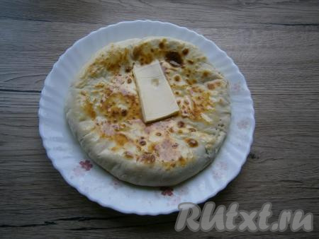 Горячую лепешку сразу же щедро смазать сливочным маслом. Аналогично пожарить остальные лепешки и смазать маслом.