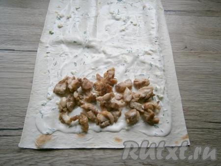 На один край лаваша выложить обжаренное куриное мясо.