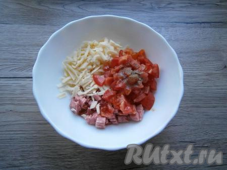 К сыру и колбасе добавить нарезанный небольшими кубиками свежий помидор, поперчить, перемешать.